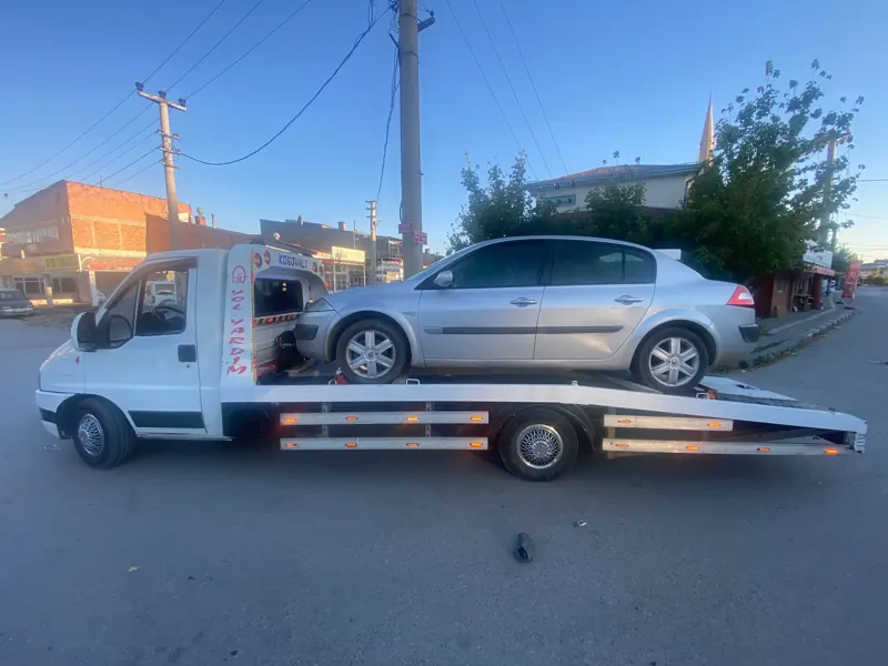 Gri Renault Megane çekicinin kasasında, şehir içinde